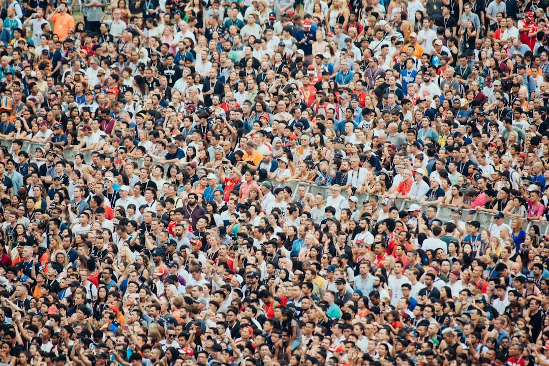 Diverse crowd of people gathered closely at an outdoor event.